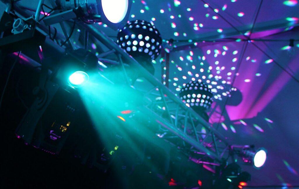 DJ lighting effect casting colourful patterns across a dark venue